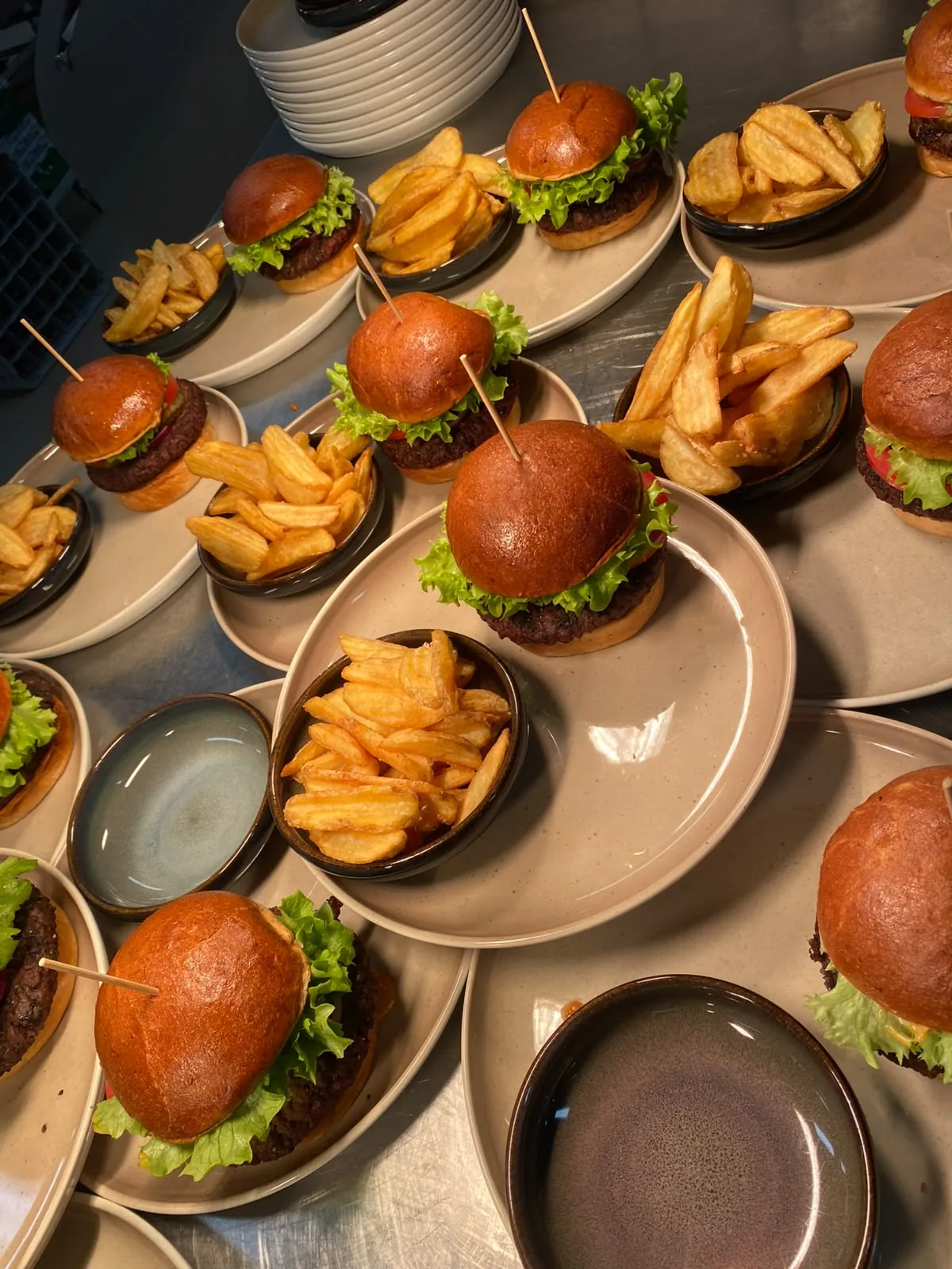Snask-burgere med pommes frites på tallerkener, klar til servering